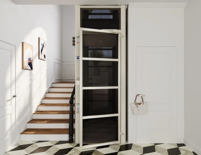 Beige home elevator by staircase Beige home elevator installed beside a staircase in a bright entryway