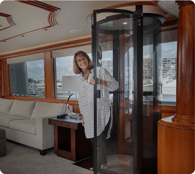 Woman Using PVE Home Elevator on Yacht Smiling woman opening the door of a PVE home elevator aboard a yacht